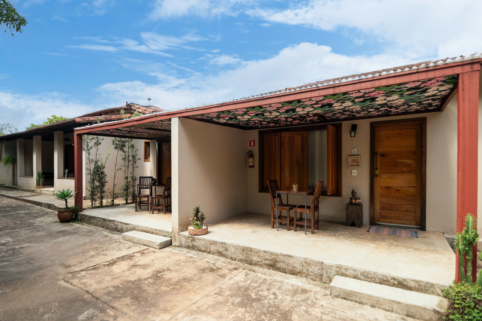 Fachada das suítes com varandas e céu azul
