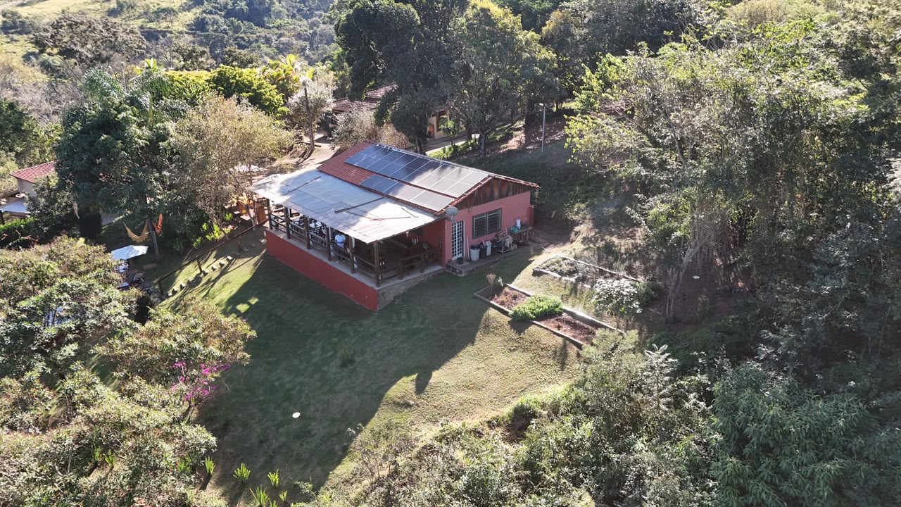 Vista aérea da pousada com painéis solares no telhado