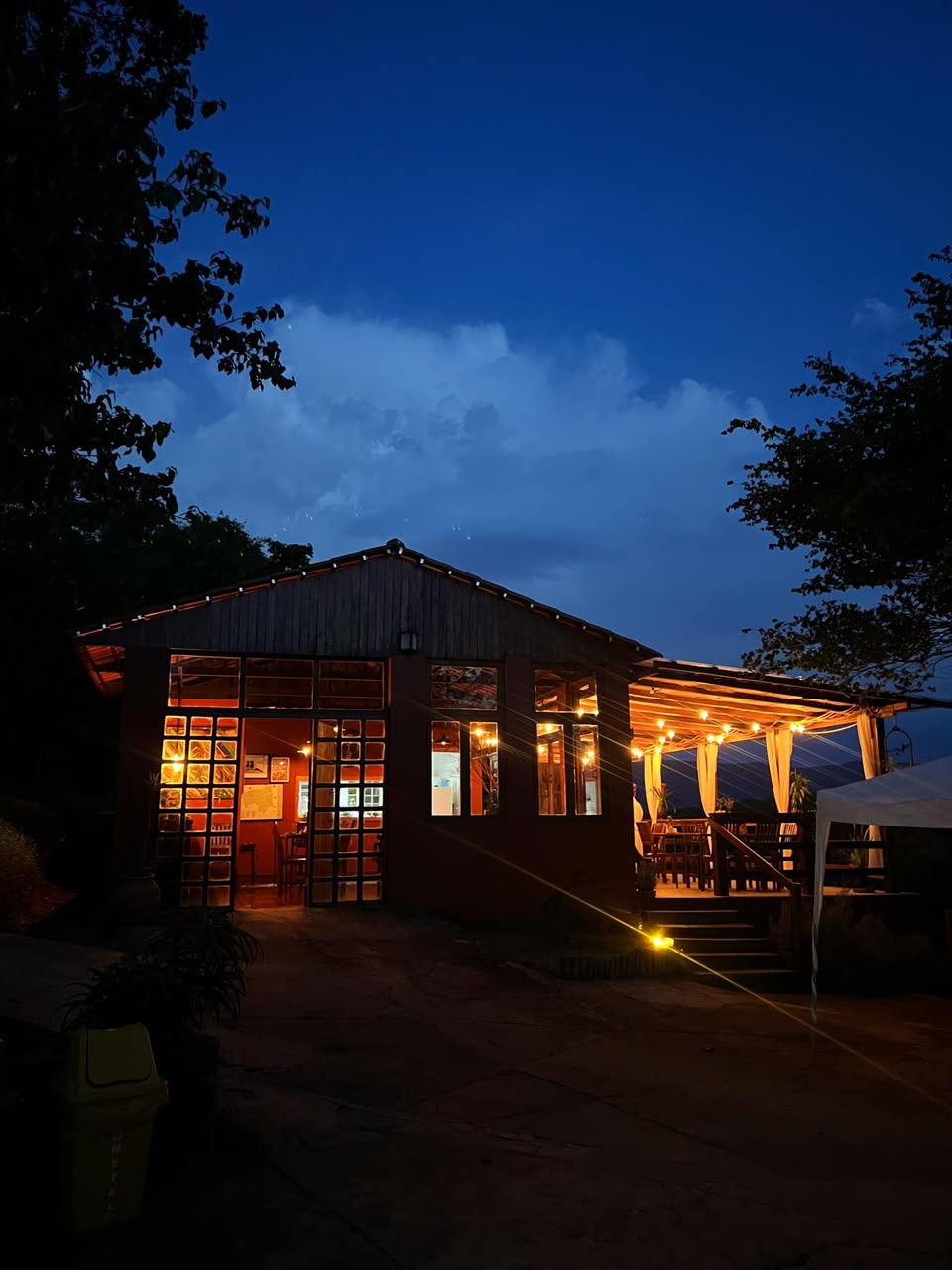 Fachada iluminada do restaurante da Villa Domaso ao anoitecer