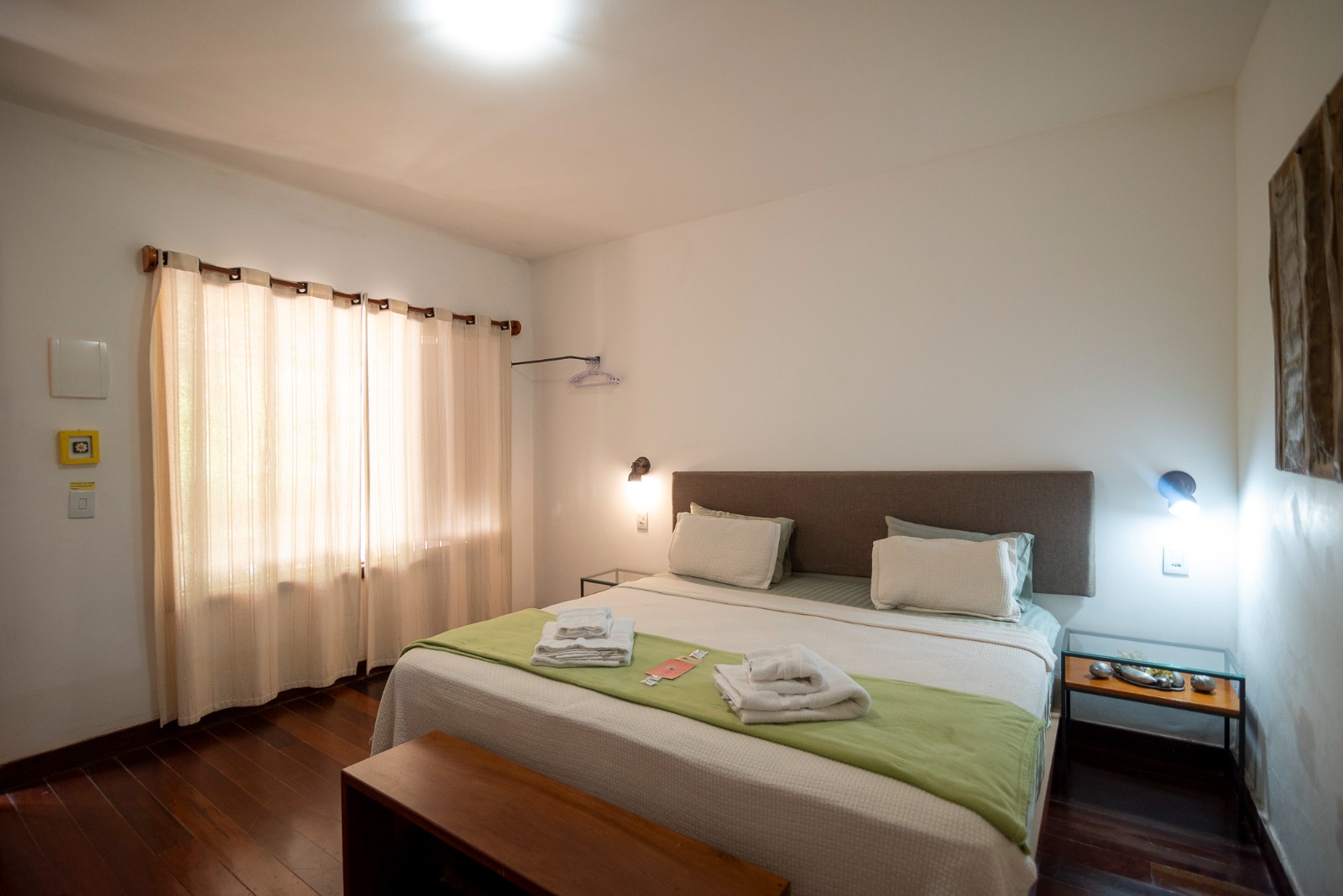 Suíte de casal com cama king size e iluminação quente