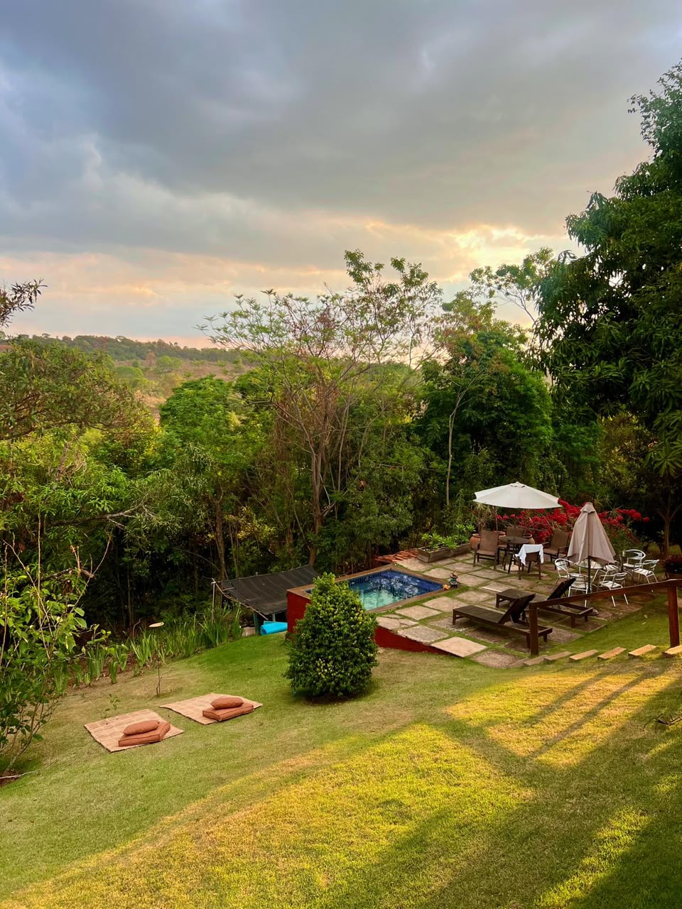 Piscina e jardim da pousada ao entardecer